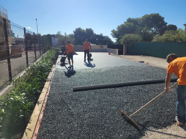Ouvriers pose enrobé gravier parking pharmacie